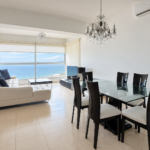 Furnished living and dining area with Bay of Panama views at Vista del Mar 25B